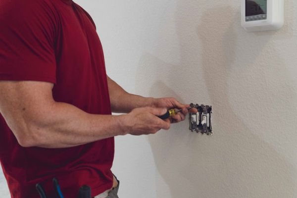 Meeks Electrician Repairing wall light switch in new residence
